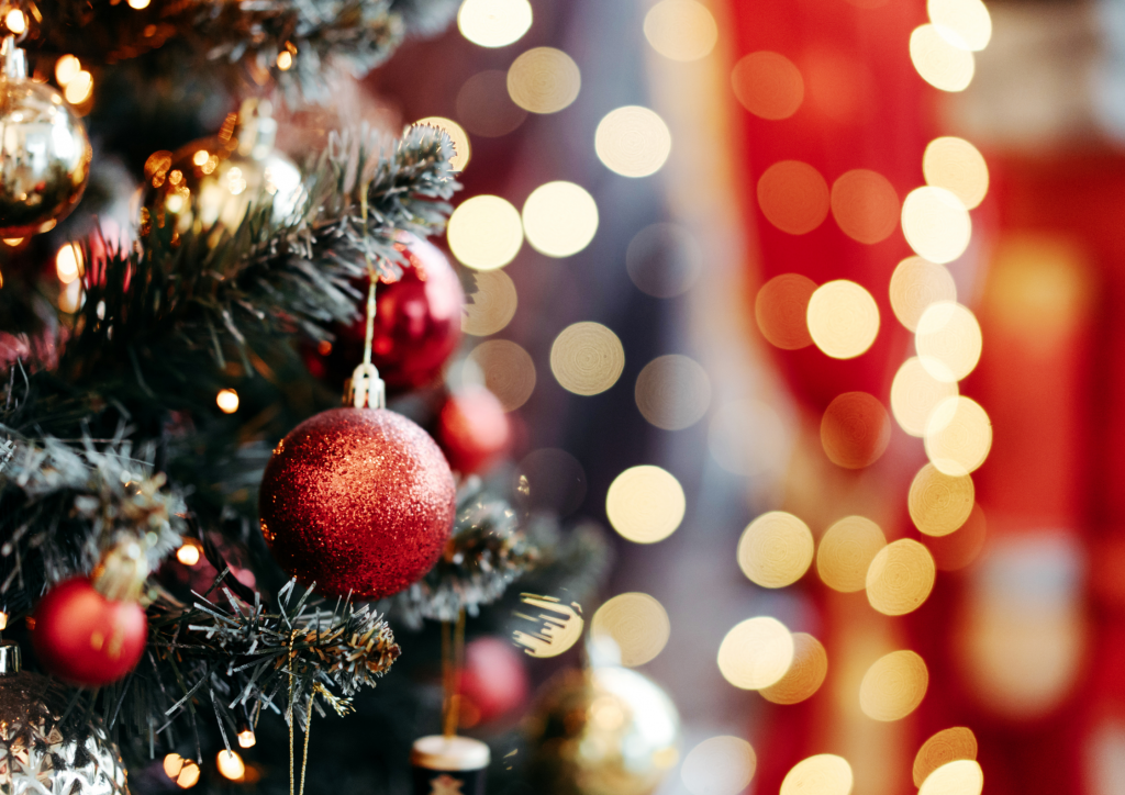 Close up picture of a Christmas tree with red baubles in the forefront