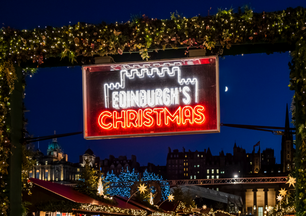 Photo of Edinburgh's Christmas market sign with the Old Town in the background